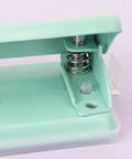 Close-up of mint 2 Hole Puncher with Waste Tray, 10 Sheet Capacity, featuring metal construction and non-slip base for office use.