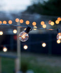 Outdoor String Lights 50Ft With 55 G40 Globe Bulbs Connectable Globe String Lights for patio shown hanging in a backyard
