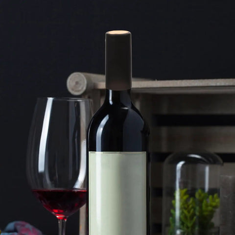A wine bottle sealed with Wine Heat Shrink Capsules Set 100 Pieces With PVC Bottle Sealing Film Disposable Shrink Wrap Caps In Black for freshness.