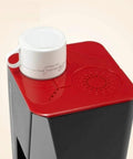 Top Shelf Automatic Espresso Maker Crushing Your Morning Grind While Pouring Killer Lattes Or Chilled Cold Brew Sips Around The House With Easy Drip Coffee And Tea Capabilities, with a white cup on red top.