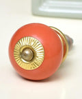 Fifty Pack Vibrant Orange Ceramic Drawer Knobs With Rounded Corners And A Total No Sweat Install For Kitchen Cabinets And Dressers That Brings A Super Chill Vibe To Your Home Decor - close-up of a vibrant orange ceramic knob with a gold accent.