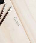 Top Tier 8 Pieces Heavy Duty Stainless Steel R Shape Cotter Pins With Wavy Design on a wooden surface among makeup tools.
