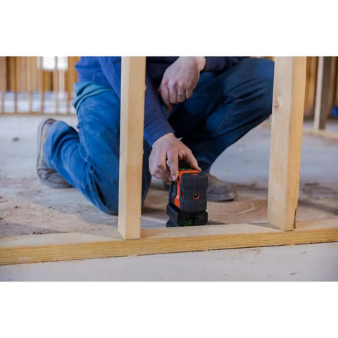Person using Green Laser Level Kit With Self Leveling 5 Dot GreenBrite Technology on a wooden frame on the job site