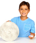 Child holding Moon In My Room Light Up Lunar Phases Kit With Remote Control, showcasing realistic moon detail.