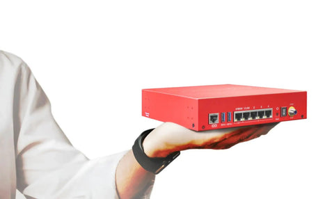 Person holding T125-W WiFi 7 Firewall with 5 Year Total Security Suite for remote offices, red device with multiple ports visible