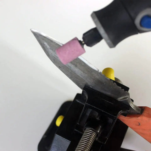 20 Piece Rotary Grinding Stone Bits Set With One Eighth Inch Shank sharpening a knife blade with pink abrasive stone