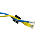 Two Ethernet cables secured with a black self-adhesive cable clip, part of 100 Pack Self Adhesive Cable Clips Heavy Duty Black Plastic Cord Management Brackets Peel And Stick Wire Ties Tame Your Wire Clutter And Keep Pc Usb Cords Tangle Free.