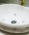 Slick Ceramic Oval Vessel Sink For Modern Bathroom Counters Smooth Glazed Finish with floral design and 12 Liter capacity.