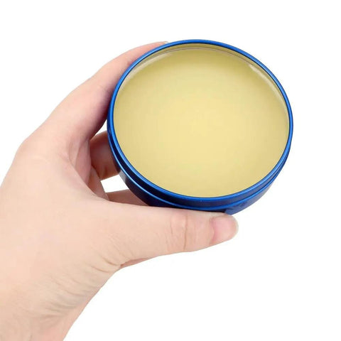 Hand holding a blue container of MCN UV80 Paste Flux No Clean Soldering Tin for PCB BGA PGA SMD use with electric soldering iron.