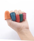 Hand holding five colorful neoprene finger sleeves from the 30 Pack Neoprene Finger Sleeves Heat Resistant Protective Covers With Non Slip Grip Durable Work Gear For Mechanics No Sweat Protection For Tough Industrial Job Sites.