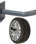 Heavy Duty 12 Inch Wall Tire Hanger Kit With Universal Multi Tool Storage Hooks Protective Sleeves Screws And Anchors Included Galvanized Steel Powder Coated Black For Garage Or Shop Organization showing hanger and mounted tire.