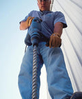 Person using Fixed-Depth Drill Bit MDPL037DIA For Quarter-Inch Drop-In Anchors on concrete surface with a power drill for structural work.