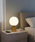 11 Inch Modern Gold Globe Table Lamp With Milk White Glass Shade And Sturdy Metal Base on a bedroom bedside table