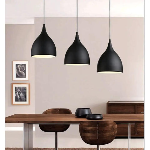 Dark Antique Farmhouse Pendant Light with Single Hanging Shade above a wooden dining table in a modern setting.