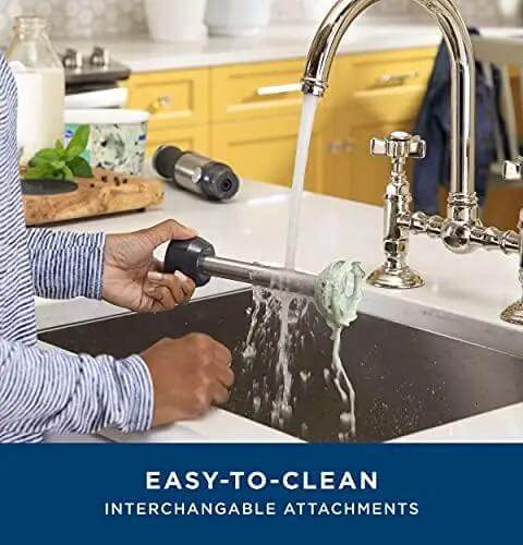 No Sweat 500 Watt Stainless Steel Immersion Blender With Removable Whisk And Spout Blending Jar For Thick Smoothies Quick Purees And Bold Homemade Sauces Dual Speed Hand Blender Kit being rinsed in a sink.