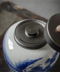 Solid Ceramic Tea Canister For Loose Leaf Storage, Airtight Kitchen Jar with moisture-proof lid being opened.