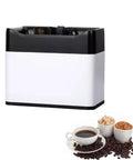 Elite Electric Portafilter Cleaner For Coffee Grounds Shakes Pucks Loose In A Flash With Dual Spin Brushes Plus The Matched Knock Box Included No Sweat on a counter with coffee cups and beans.