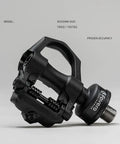 Dual Sensing Pedal Based Power Meter with extra cleats for road cycling, easy to move between bikes, black pedal showing bearings.