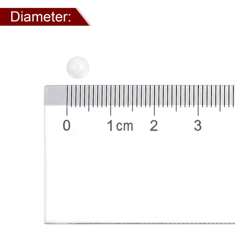 White 5 mm ceramic zirconia bearing ball shown next to a ruler for scale