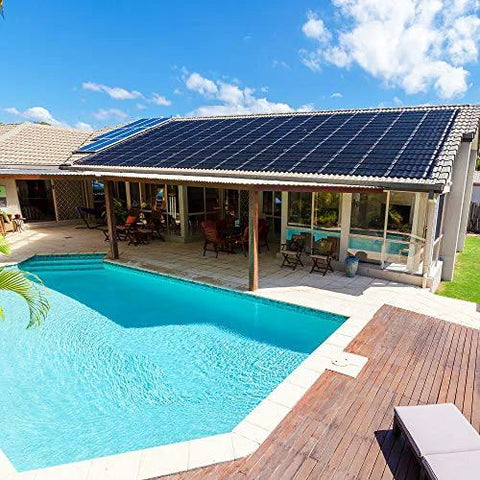 Backyard with an in-ground swimming pool, wooden deck, and house with solar panels on the roof.