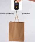 Thickened Kraft Paper Shopping Bags With Handles 60 Pack Durable Brown Paper Tote Bags for weight testing on scale display.