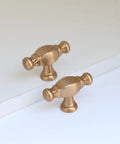 Two modern champagne bronze zinc alloy cabinet knobs on white surface, 10 Pack Champagne Bronze Bar Cabinet Knobs Zinc Alloy Furniture Drawer Pulls.