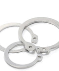 Three Piece Set Of 304 Stainless Steel External Retaining Rings and Circlips on white background, designed for axles and bearings.