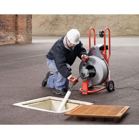 Heavy Hitter Auto Feed Drum Drain Snake Machine With 3 4 Inch C 100 Inner Core Cable in use for clearing pipe blockages.