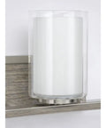Close-up of clear and etched glass shade on faux wood back plate of Four Light Linear Chandelier In Brushed Nickel