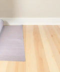 Slick And Tough Foam Underlayment Roll For Laminate And Wood Flooring With Moisture Resistant Barrier laid out on wooden floor.