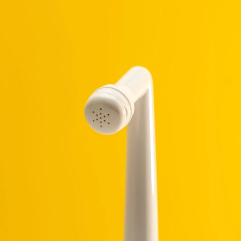 Angled nozzle of MicroJet MJ 450 Portable Bidet And Peri Bottle Sprayer For Travel, ergonomic design, yellow background