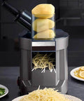 Front view of a gray 4-in-1 electric vegetable slicer and chopper with dual feed chutes; potatoes stacked on top.