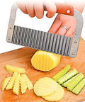 Crinkle-cut slicer with wooden handle and stainless steel blade slicing potatoes on a cutting board