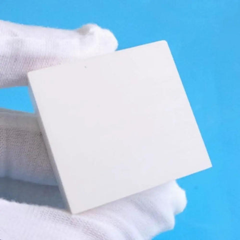 Boron Nitride Ceramic Sheet Pad and Plate for heat proof performance held by a gloved hand, size 150 x 150 x 2 mm.