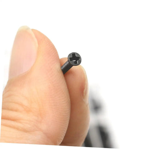 Solid Gear Carbon Steel Miniature Screw Assortment Loaded With Round Head Countersunk Bolts Inside A Compact Travel Kit For Hassle Free Notebook Glasses Repairs, close-up of a black countersunk screw.