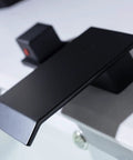 Close-up of Waterfall Bathroom Sink Faucet Set Matte Black Sleek Widespread 8 Inch Deck Mounted 3 Hole Basin With 2 Square Handles