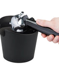 Hand using portafilter with Coffee Knock Box Pro Round With Shock Absorbent Base And Removable Bar Non Slip, 4.8in durable design