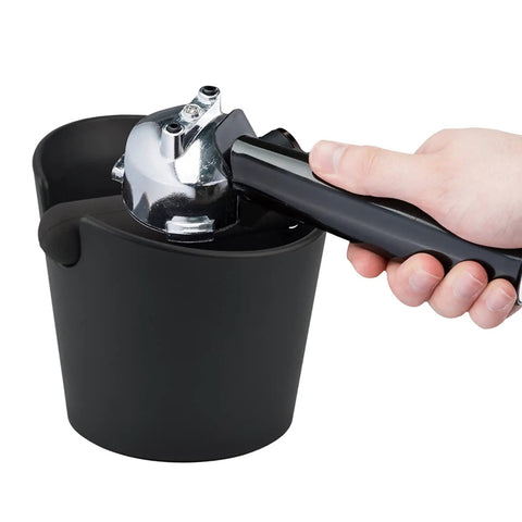 Hand using portafilter with Coffee Knock Box Pro Round With Shock Absorbent Base And Removable Bar Non Slip, 4.8in durable design