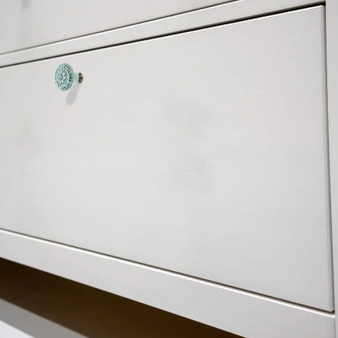 Close-up of a light drawer featuring a Six Piece Vintage Ceramic Drawer Knob Set With Single Hole Cabinet Handles Featuring Floral Celadon Blue Pattern.
