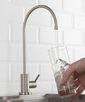 Purita No Lead Kitchen Water Filter Faucet With Spot Free Stainless Steel Finish Stand Alone Beverage Faucet running water into a glass