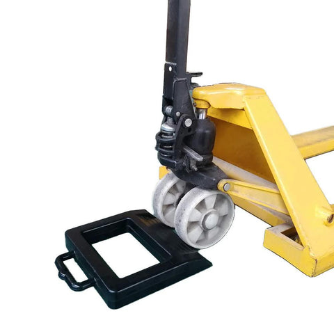 Rubber Pallet Jack Chock Heavy Duty Wheel Stopper for Pallet Jacks and Trucks stabilizes wheels, black, shown with yellow pallet jack