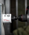 Hole Dozer 3-inch bi-metal hole saw, Milwaukee, mounted on a red cordless drill cutting metal (side view).