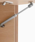 Smooth Acting Gas Strut Cabinet Hinge With Safety Lift Support And Reliable Soft Close Function For Toy Boxes And Cabinets, Durable Stainless Steel Core, Easy No Sweat Install, 2 Piece Set mounted on wooden cabinet.