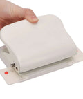 Hand holding Heavy Duty Metal Hole Punch For Home Office Desk, 10 hole punch in white with storage and guides.
