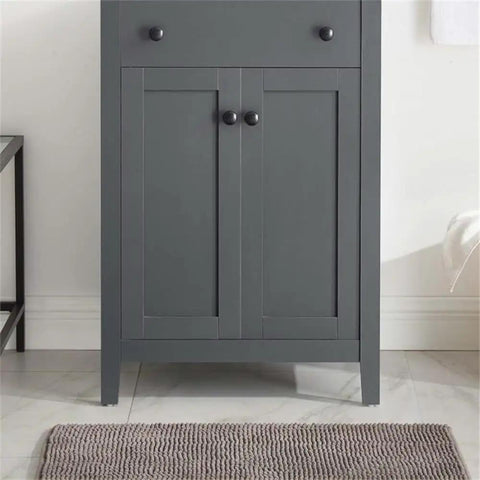 Elegant gray bathroom cabinet with dual doors and sleek lines on a tiled floor.