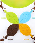 Four leaf-shaped silicone door stops in green, blue, brown, and yellow with lanyards; Leaf Shaped Door Stop With Lanyard, Kid Safe Silicone Door Wedge That Keeps Doors From Slamming, Finger Protector For Home Kitchen Garden And Office, Lightweight Anti Fold Design, Yellow.