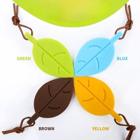 Four leaf-shaped silicone door stops in green, blue, brown, and yellow with lanyards; Leaf Shaped Door Stop With Lanyard, Kid Safe Silicone Door Wedge That Keeps Doors From Slamming, Finger Protector For Home Kitchen Garden And Office, Lightweight Anti Fold Design, Yellow.