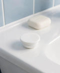 5pcs Silicone Bathtub Jet Cover Plug 30-31mm White for Bubble Ports placed on a bath ledge next to soap.