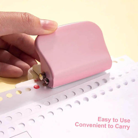 Person using pink Six Hole Puncher For Loose Leaf Notebooks on paper