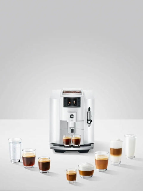 Top Tier Automatic Espresso Machine Bundle In Piano White With Glass Milk Container And Clearyl Smart Filter Cartridge For Seamless One Touch Operation And Premium Daily Grinds with assorted drinks.